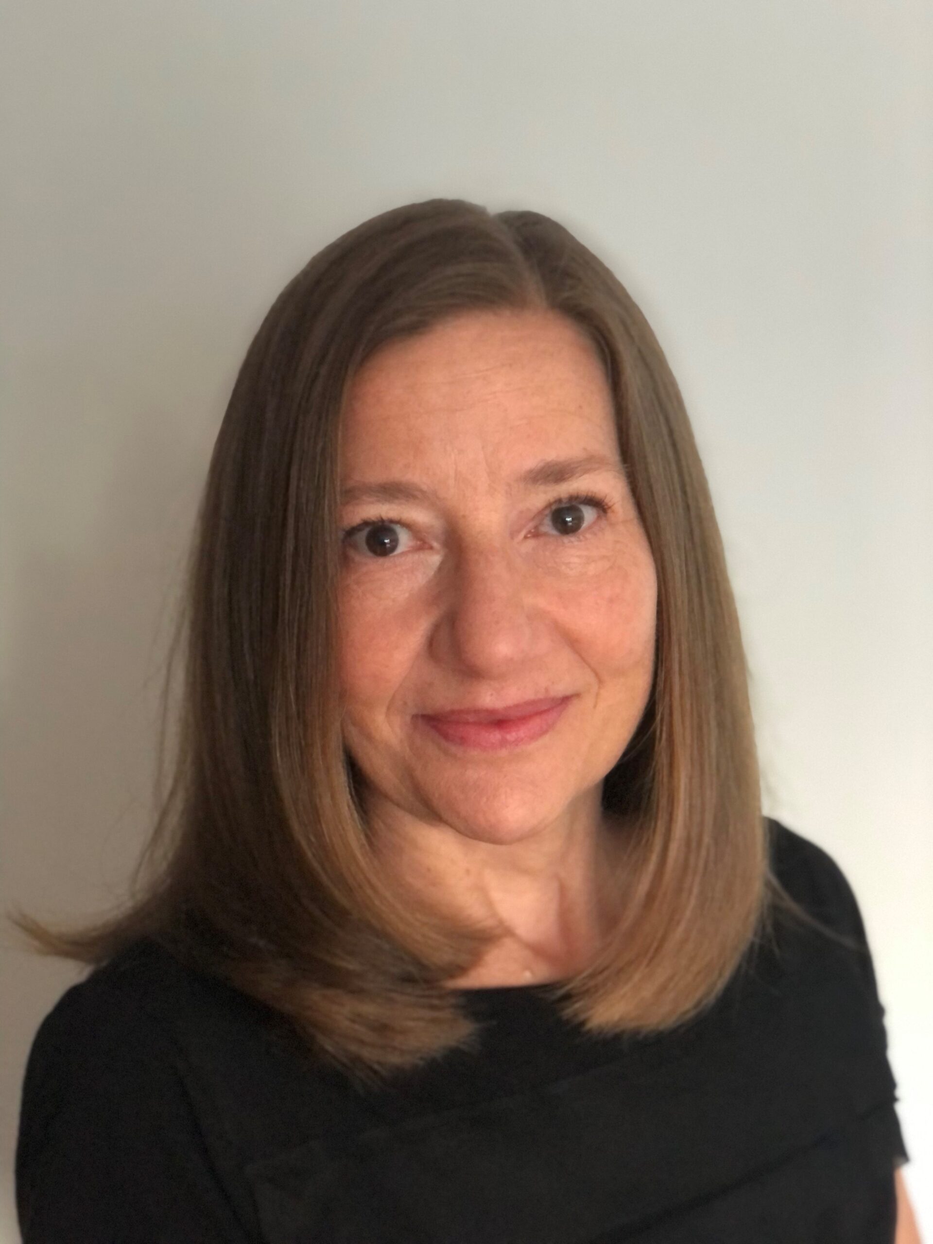 A photo of a woman with straight light brown shoulder-length hair.