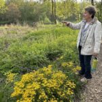 A woman pointing to a garden