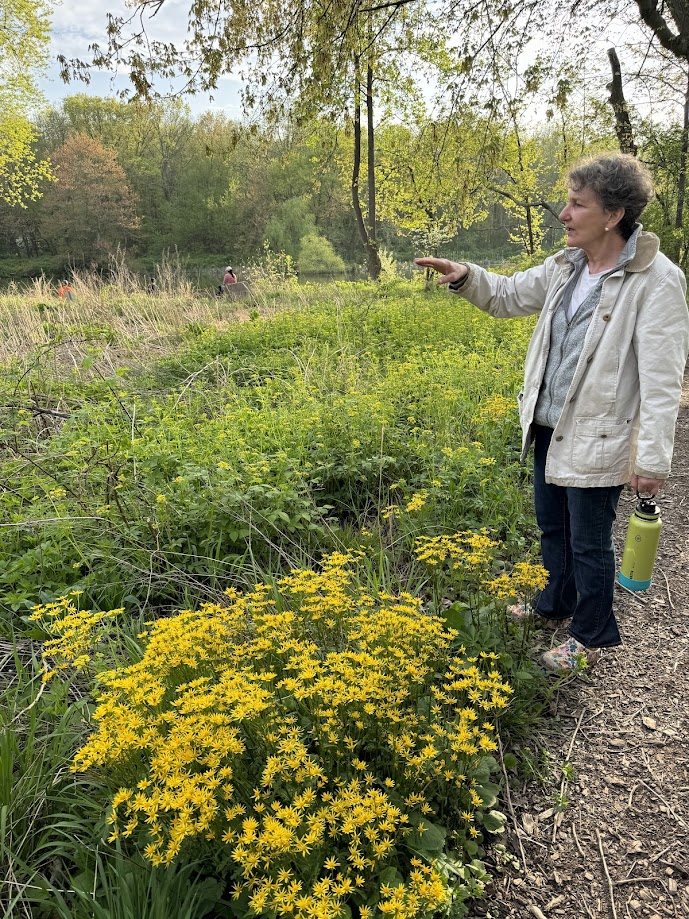 A woman pointing to a garden