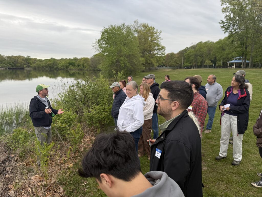 A group of people learning near a lake. 