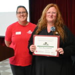 Two people posing with a certificate